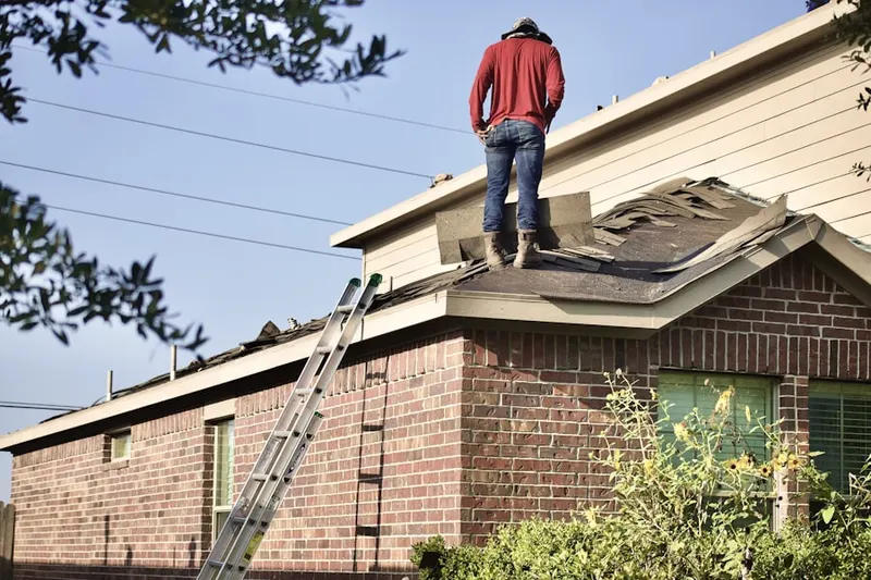 Professional roofer working on a residential roof in Bellmawr